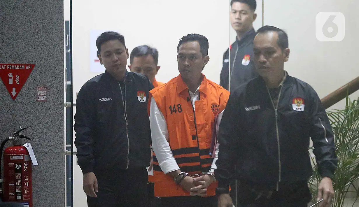 Bupati Cilacap, Jawa Tengah, Syamsul Auliya Rachman saat digiring petugas menuju mobil tahanan di Gedung Merah Putih Komisi Pemberantasan Korupsi (KPK), Jakarta, Sabtu (14/3/2026). Komisi Pemberantasan Korupsi (KPK) resmi menahan dua tersangka terkait dugaan pemerasan dan penerimaan lainnya di lingkungan Pemerintah Kabupaten Cilacap, Jawa Tengah. (Liputan6.com/Helmi Fithriansyah)