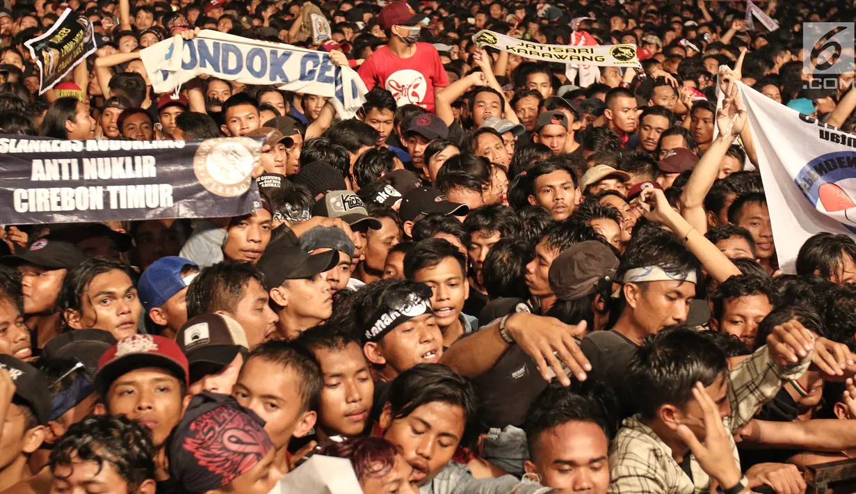 Para slankers membentangkan spanduk pada konser perayaan ulang tahun ke-34 Slank di JIExpo Kemayoran, Jakarta Pusat, Selasa (26/12). Konser kali ini menjadi ajang reuni bagi Slankers, penggemar Slank, dari penjuru Indonesia. (Liputan6.com/Herman Zakharia)