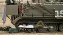 Tentara Israel tidur di samping kendaraan militer di dekat perbatasan Gaza-Israel, Jumat (19/10). Warga Palestina telah menggelar aksi protes di sepanjang perbatasan Gaza dengan Israel sejak 30 Maret. (AP Photo/Ariel Schalit)