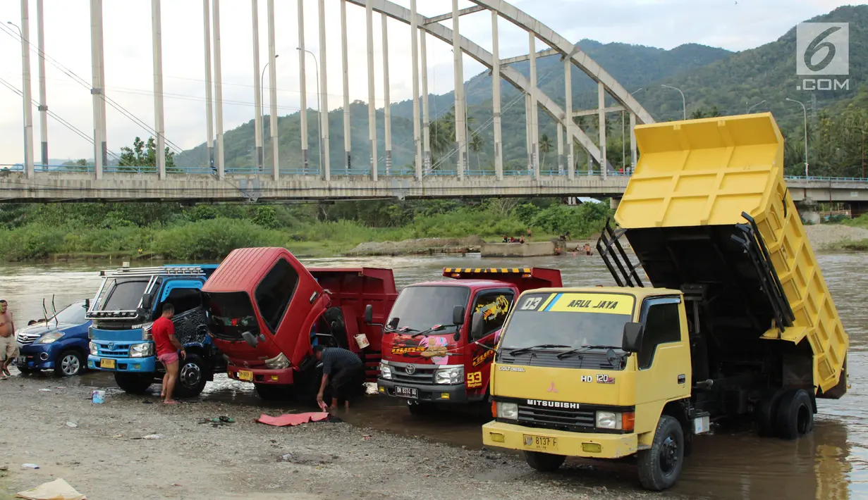 Sejumlah pemilik kendaraan memanfaatkan aliran sungai Bone untuk mencuci di kompleks Jembatan Talumolo II, Kelurahan Talumolo, Gorontalo, Senin (19/11). Tempat itu menjadi kawasan pencucian kendaraan bermotor yang gratis.  (Liputan6.com/Arfandi Ibrahim)