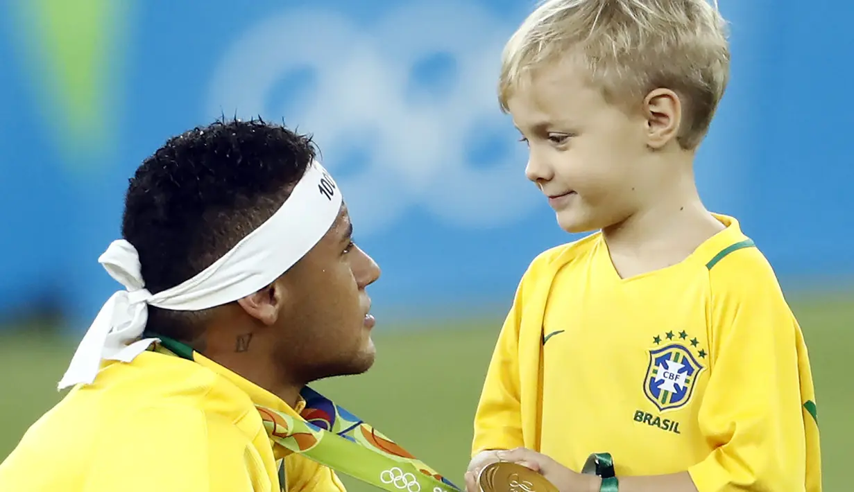 Neymar melakukan selebrasi bersama anaknya usai meraih medali emas pada final sepak bola melawan Jerman di Stadion Maracana, Rio de Janeiro, (21/8/2016) dini hari WIB. (AFP/Odd Andersen)
