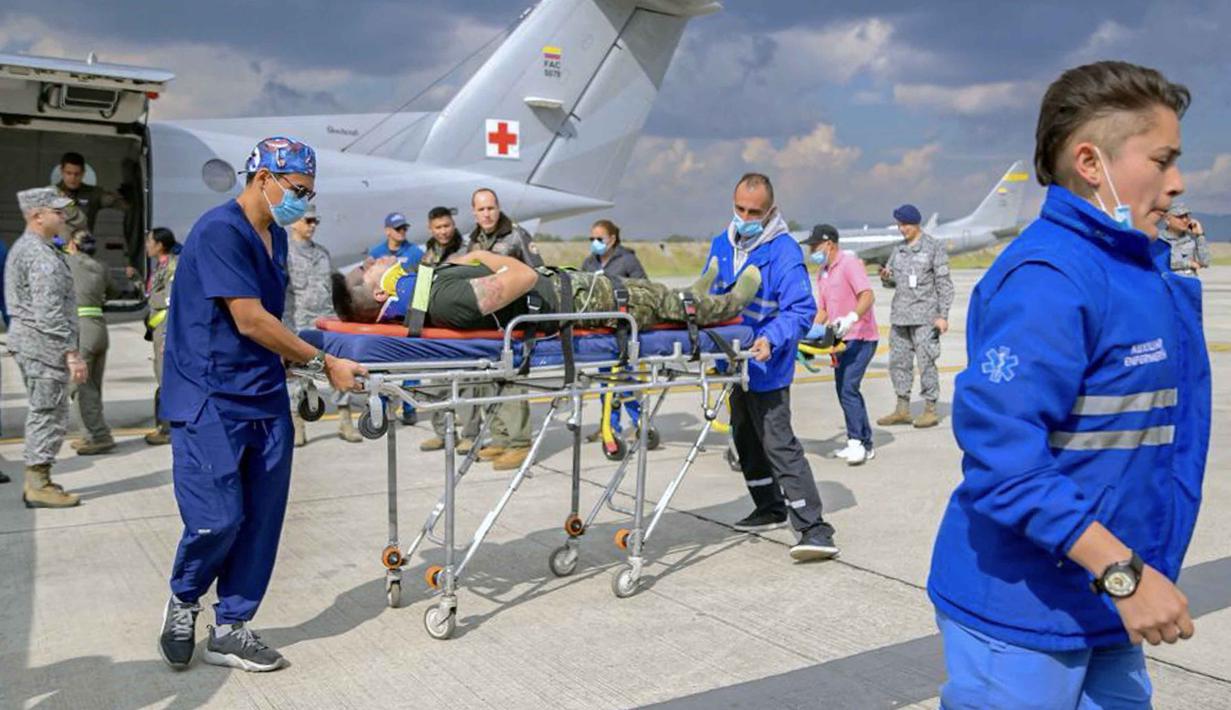 Dari jumlah tersebut, dua penumpang adalah polisi sementara 112 lainnya anggota militer. Tampak dalam foto yang dirilis oleh Angkatan Bersenjata Kolombia ini menunjukkan anggota Angkatan Udara Kolombia dan paramedis membawa seorang korban luka di pangkalan udara CATAM di Bogota, Kolombia, pada 23 Maret 2026. (Handout/Colombian Armed Forces/AFP)