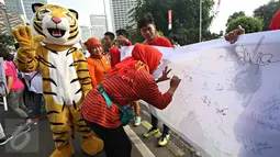 Warga memberikan tanda tangan dalam kampanye bertajuk 'Ayo Hentikan Kejahatan Lingkungan dan Kehutanan' di Jakarta, (20/12). Aplikasi ini bertujuan mengajak masyarakat aktif dalam memberikan laporan kejahatan lingkungan. (Liputan6.com/Immanuel Antonius)