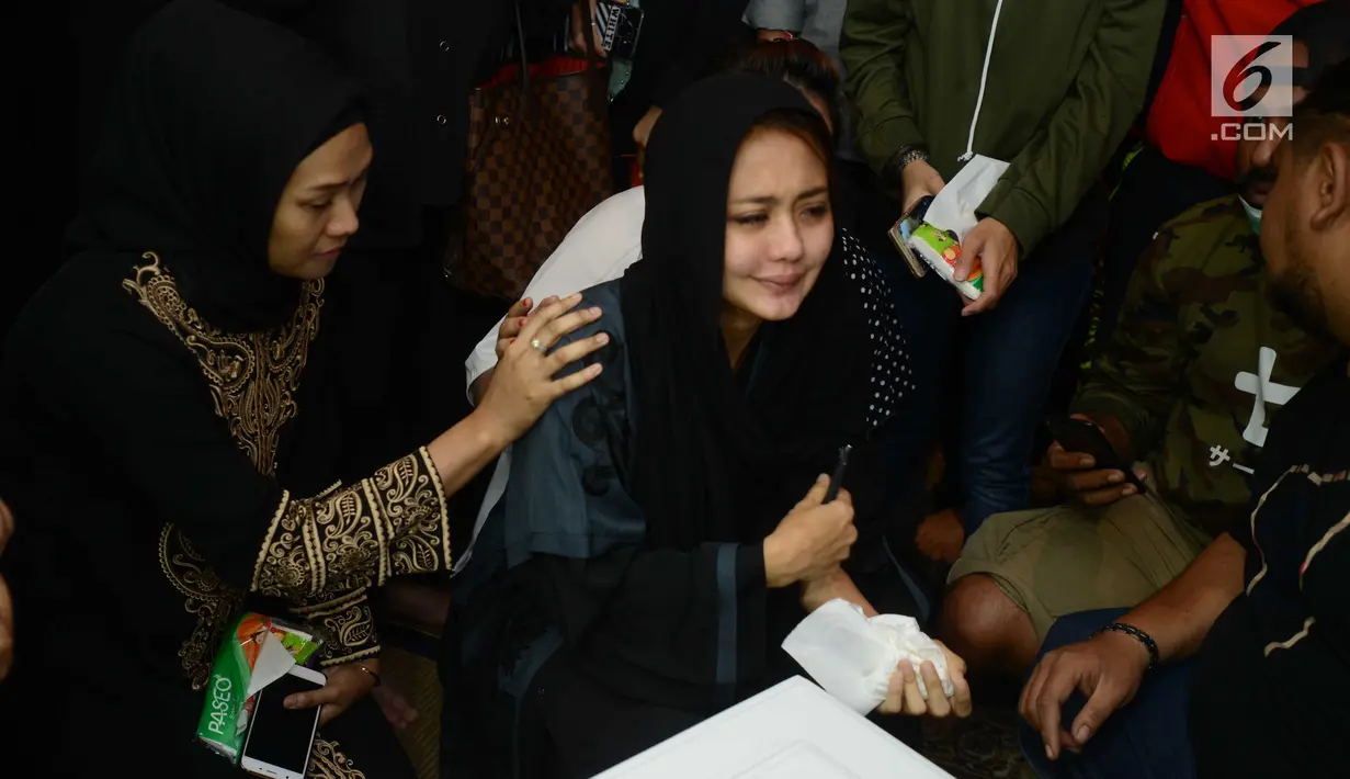 Istri gitaris grup band Seventeen Herman Sikumbang, Juliana Muhtar menangis saat menerima kedatangan jenazah suami di rumah duka di Pancoran, Jakarta, Senin (24/12). Uli begitu terpukul dengan meninggalnya sang suami. (Kapanlagi.com/Bayu Herdianto)