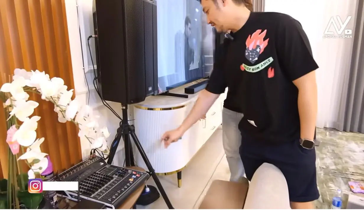 Selain buat menghabiskan waktu bersama anak dan istri, ruang ini juga sebagai tempat hiburan Angga sepulang kerja. Selain televisi besar juga terdapat peralatan untuk karaoke. Angga mengaku daripada karaoke di luar, mending dirumah sendiri tak mengeluarkan biaya. [Youtube/Afdhal Yusman]