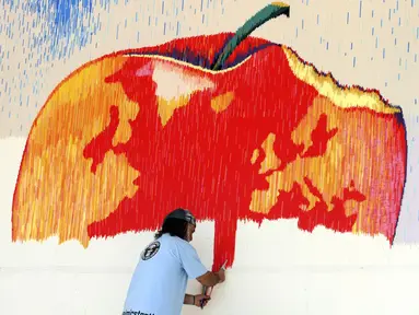 Seniman Saimir Strati saat membuat karya seni mozaik dari sedotan plastik di Fier, Albania, Jumat (18/7/14). (REUTERS/Arben Celi)