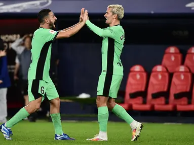 Pemain Atletico Madrid #06 Koke (Kiri) dan Antoine Griezmann merayakan kemenangan mereka atas Osasuna pada akhir laga penutup jornada ketujuh Liga Spanyol di Stadion El Sadar, Jumat (29/9/2203) dini hari WIB. (ANDER GILLENEA / AFP)