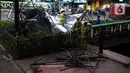 Petugas pemadam kebakaran memotong rangka reklame di Jalan Soepomo, Jakarta, Sabtu (28/5/2022). Hujan disertai angin kencang pada pagi tadi membuat papan reklame roboh sehingga membuat kemacetan arus lalu lintas di jalan tersebut. (merdeka.com/Imam Buhori)