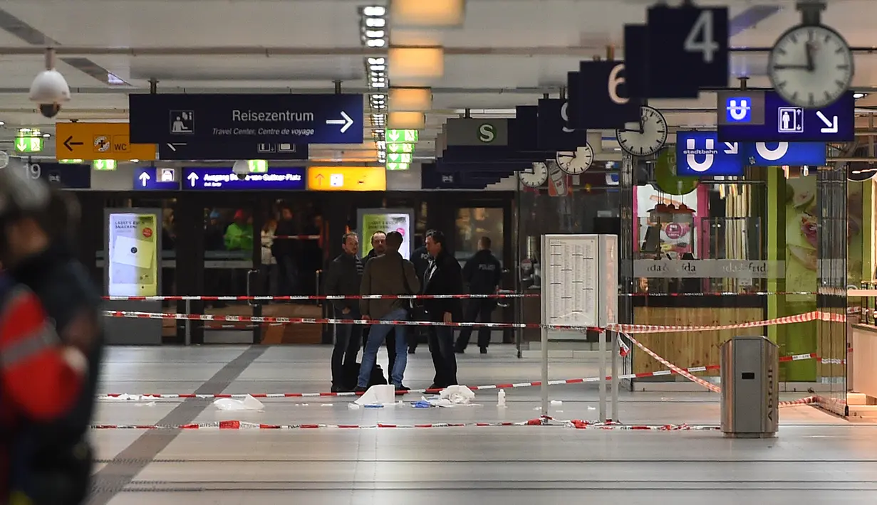Garis polisi terpasang dekat lokasi seorang pria bersenjata kapak yang mengamuk di sebuah stasiun kereta api di Dusseldorf, Jerman, Kamis (9/3). Polisi telah menutup stasiun untuk sementara hingga penyelidikan selesai. (Patrik STOLLARZ/AFP)