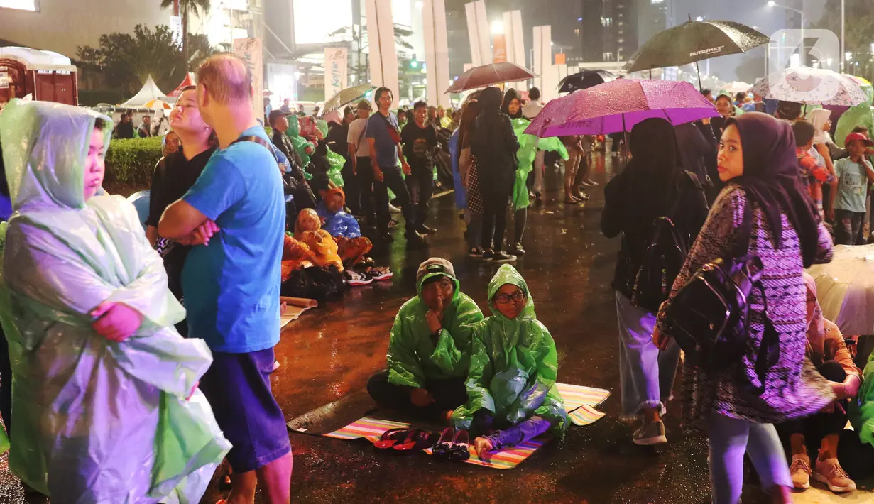 Masyarakat mulai memadati car free night di kawasan Thamrin, Jakarta, Selasa (31/12/2019). Meski diguyur hujan masyarakat mulai memadati kawasan tersebut untuk menikmati malam pergantian tahun 2019. (Liputan6.com/Angga Yuniar)