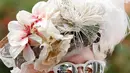 Seorang wanita mengenakan topi atau fascinator unik bermotif bunga saat menghadiri ajang pacuan kuda Royal Ascot di Ascot, Inggris, Selasa (18/6/2019). Royal Ascot menjadi ajang bagi wanita Inggris untuk tampil dengan fascinator unik. (AP Photo/Alastair Grant)