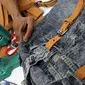 Perajin menyelesaikan pembuatan tas dari bahan celana jeans bekas di Legok, Tangerang, Banten, Senin (11/11/2019). Tas berbahan jeans itu dipasarkan ke kawasan Bandung serta pasar daring. (merdeka.com/Arie Basuki)