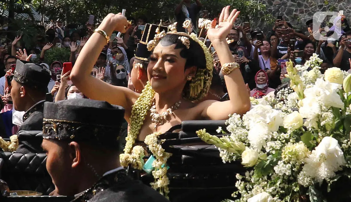 Pasangan pengantin Kaesang Pangarep dan Erina Gudono (kanan) menaiki kereta saat prosesi kirab Ngunduh Mantu di kawasan Selamet Riyadi, Solo, Jawa Tengah, Minggu (11/12/2022). Kirab ngunduh mantu pernikahan putra bungsu Presiden Joko Widodo, Kaesang Pangarep dan istrinya Erina Gudono yang dimulai dari Loji Gandrung menuju Pura Mangkunegaran tersebut disaksikan ribuan masyarakat Solo dan sekitarnya. (Liputan6.com/Herman Zakharia)