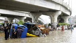 Kendaraan terguling setelah hujan monsun mengguyur deras di Kota Karachi, Pakistan, 25 Agustus 2020. Hujan deras membuat kekacauan di beberapa bagian kota tersebut, dengan air hujan menyebabkan banjir serta merendam jalan, kendaraan, maupun area-area berdataran rendah. (Xinhua/Str)