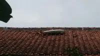 Pintu pesawat jatuh di atap rumah warga di Ciganjur, Jakarta Selatan. (Laiputan6.com/Nafiysul Qodar)