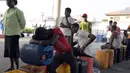 Pria Nigeria tertidur di atas jerigen saat antre mengisi bahan bakar di sebuah SPBU di Lagos, Selasa (1/12). Krisis bahan bakar yang telah melanda Nigeria dalam beberapa bulan terakhir menyebabkan antrean panjang di SPBU. (AFP PHOTO/PIUS Utomi EKPEI)