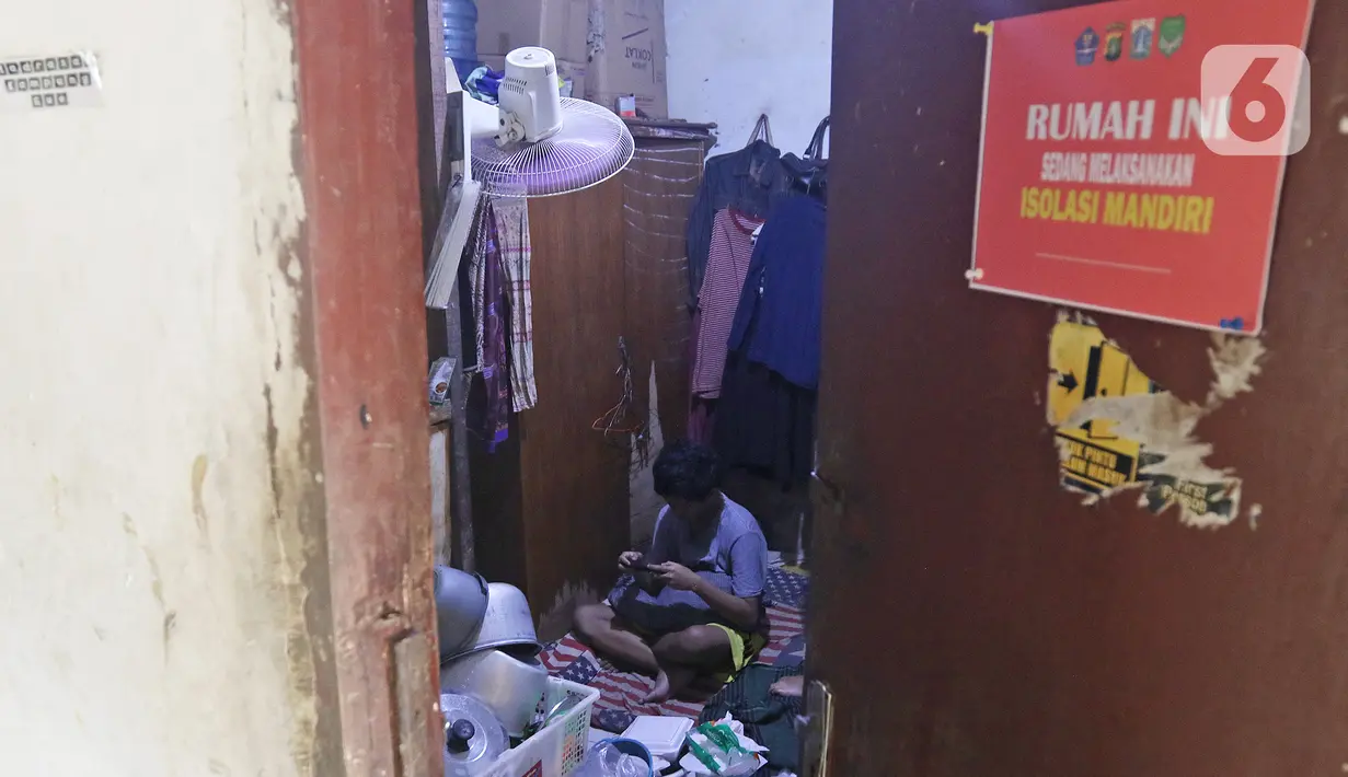 Seorang warga yang sedang isolasi madiri di rumahnya saat penerapan mikro lockdown RT 006 RW 01, Gandaria Selatan, Cilandak, Jakarta, Selasa (22/6/2021). Pemprov DKI menerapkan mikro lockdown di kampung tersebut lantaran adanya 17 warga yang positif Covid-19. (Liputan6.com/Herman Zakharia)
