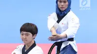 Atlet Taekwondo putri Indonesia, Defia Rosmaniar saat laga bersama Yun Jihye (Korea Selatan) pada Semifinal Women Individual Poomsae di JCC, Jakarta, Minggu (19/8). Defia Rosmaniar berhasil meraih emas. (Liputan6.com/Helmi Fithriansyah)