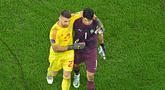 Kiper Spanyol, Unai Simon sempat saling berbincang dengan kiper Maroko, Yassine Bounou, sebelum babak adu penalti pada laga 16 besar Piala Dunia 2022 di Stadion Education City, Selasa (6/12/2022). (AFP/Manan Vatsyayana)