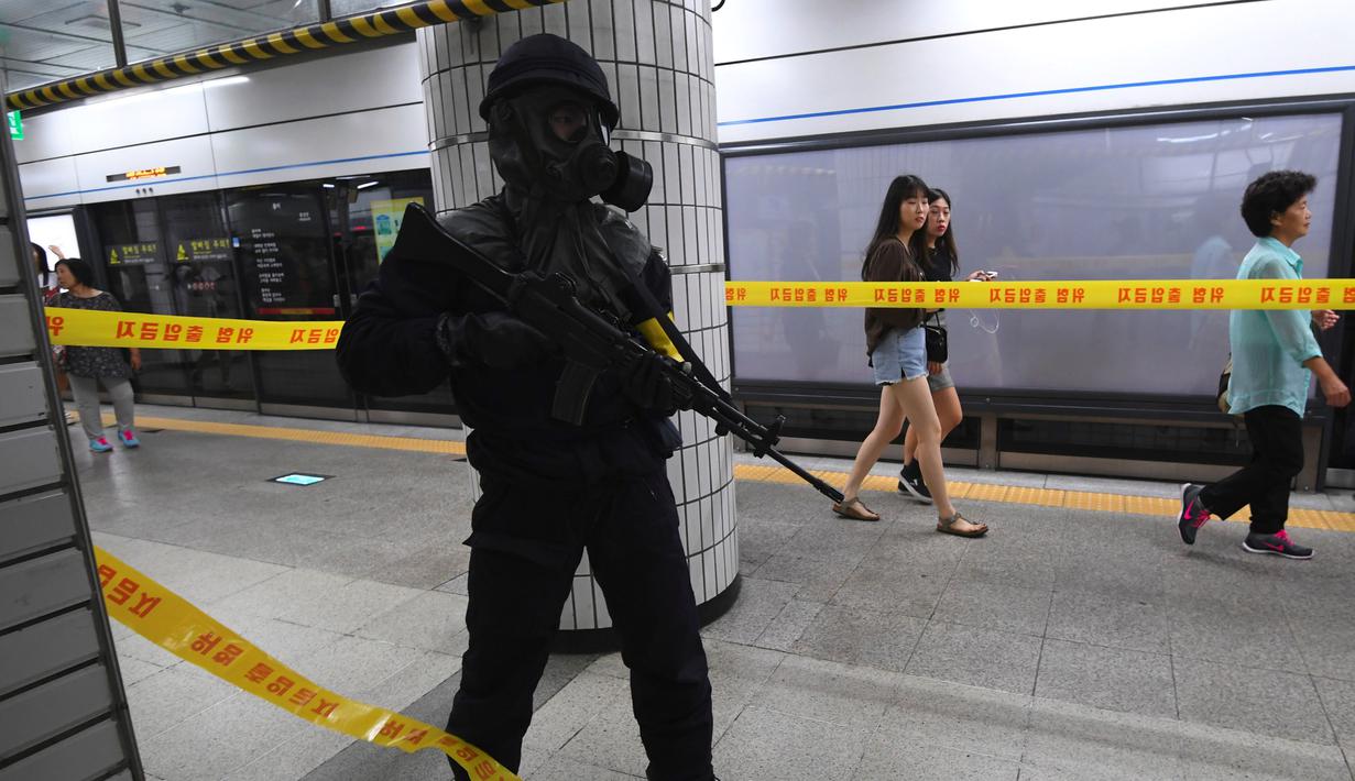 Polisi Korea Selatan berjaga saat latihan anti-teror di sebuah stasiun kereta bawah tanah di Seoul (22/8).  Puluhan ribu tentara Korea Selatan dan AS ikut serta dalam latihan militer gabungan "Ulchi Freedom Guardian. (AFP Photo/Jung Yeon-Je)