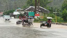 Pengendara mobil mengarungi jalan yang banjir setelah hujan lebat akibat badai tropis Agaton di Kota Abuyog, Provinsi Leyte, Filipina, 11 April 2022. (Bobbie ALOTA/AFP)