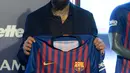 Pemain baru Barcelona, Arturo Vidal menunjukkan jersey Barcelona dalam presentasi resminya di Stadion Camp Nou, Barcelona, Spanyol, Senin (6/8). (Josep LAGO/AFP)