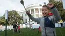 Seorang anak meluapkan kegembiraannya seusai menyelesaikan lomba menggelindingkan telur paskah di Gedung Putih, Washington, Senin (22/4). Acara tahunan itu merupakan bagian dari rangkaian memperingati Paskah yang rutin diselenggarakan Gedung Putih. (Kevin Wolf/AP Images for the American Egg Board)