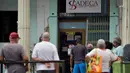 Orang-orang antre di kantor Western Union sebelum penutup kantor di Havana, Kuba, Senin (23/11/2020). Layanan transfer uang terkemuka di dunia itu menutup lebih dari 400 gerainya di Kuba menyusul sanksi ekonomi terbaru yang dikeluarkan Amerika Serikat (AS) terhadap negara itu. (Yamil LAGE/AFP)