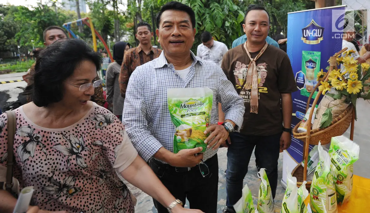 Ketua HKTI yang juga mantan Panglima TNI Moeldoko bersama istri menunjukkan beras organik di Festival Panen Raya Nusantara (Parara) yang diikuti 85 komunitas lokal di Taman Menteng, Jakarta, Minggu (15/10) (Liputan6.com/Ari)