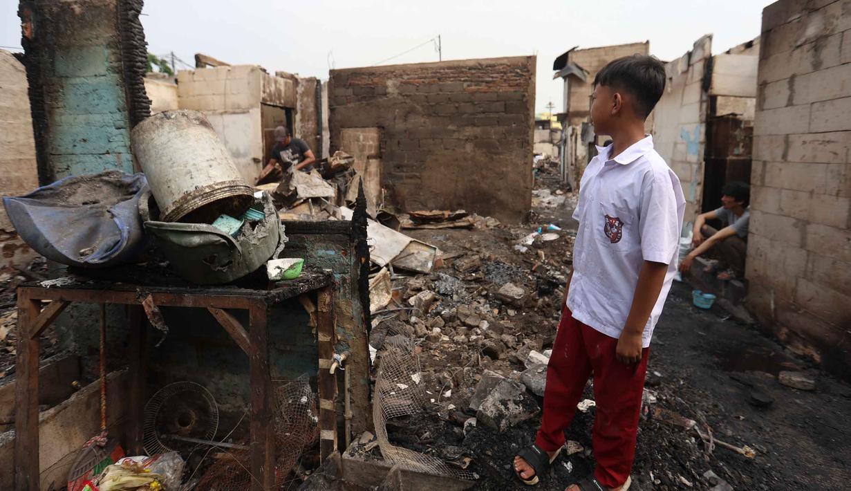 Seorang anak memandang letak jejak kebakaran di permukiman padat masyarakat di Jalan Kemayoran Gempol belakang Pasar Jiung, Kelurahan Kebon Kosong, Kecamatan Kemayoran, Jakarta Pusat, Selasa (2/6/2026). (Kapanlagi.com/Budy Santoso)