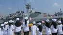 Anak-anak sekolah dasar mengibarkan bendera Indonesia dan Inggris saat menyambut kedatangan Kapal Perang Kerajaan Inggris His Majesty’s Ship (HMS) Tamar di Pelabuhan Tanjung Priok, Jakarta pada Rabu 17 Juni 2026. (BAY ISMOYO/AFP)