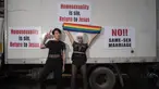 Peserta parade penyuka sesama jenis berfoto dengan poster slogan anti-gay dalam acara 'Gay Pride' di Seoul, Korea Selatan (15/7). Sekitar 10.000 warga korsel turun ke jalan untuk merayakan parade bagi kaum LGBT. (AFP Photo/Ed Jones)