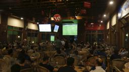 Warga Palestina menonton laga El Clasico antara Barcelona melawan Real Madrid di Gaza City, Minggu (6/5/2018). Konflik perang tak menyurutkan fenomena El Clasico. (AFP/Mahmud Hams)