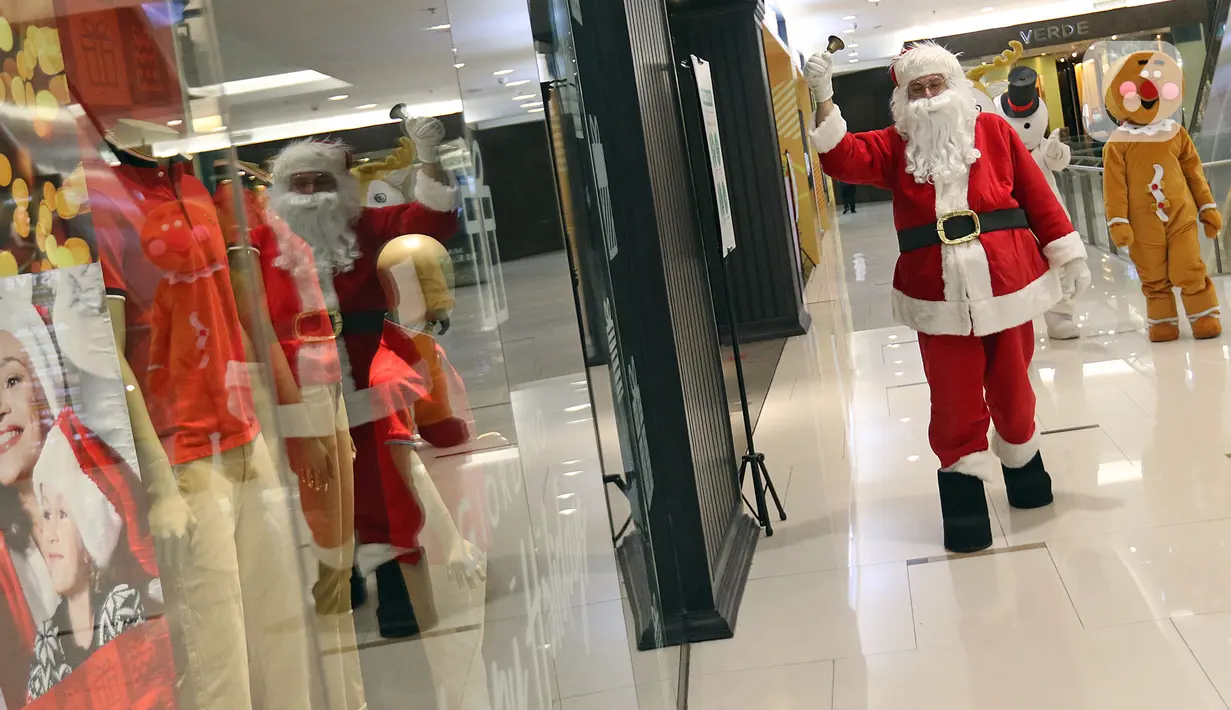 Petugas yang mengenakan kostum Sinterklas berkeliling saat menghibur pengunjung di Senayan City Mall, Jakarta, Jumat (25/12/2020). Kegiatan tersebut bertujuan untuk melengkapi kebahagiaan Natal tahun 2020. (Liputan6.com/Herman Zakharia)