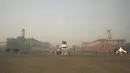 Komuter berjalan di dekat istana presiden di tengah kabut asap tebal di New Delhi, India, Kamis (3/11/2022). Pihak berwenang Delhi secara teratur mengumumkan berbagai rencana untuk mengurangi polusi udara, misalnya dengan menghentikan pekerjaan konstruksi, tetapi upaya itu tidak banyak berpengaruh. (Money SHARMA / AFP)
