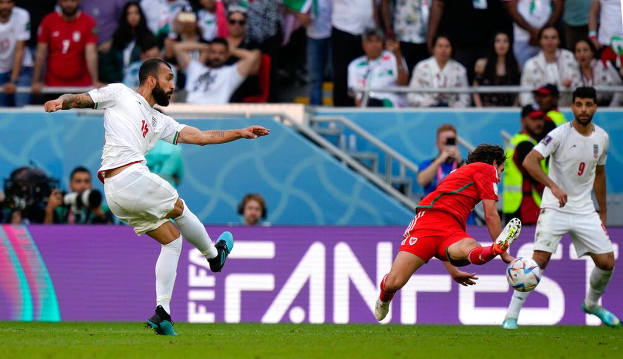Pemain Iran Rouzbeh Cheshmi menendang bola untuk mencetak gol ke gawang Wales pada pertandingan sepak bola Grup B Piala Dunia 2022 di Stadion Ahmad Bin Ali, Al Rayyan, Qatar, Jumat (25/11/2022). Iran mengalahkan Wales dengan skor 2-0. (AP Photo/Frank Augstein)