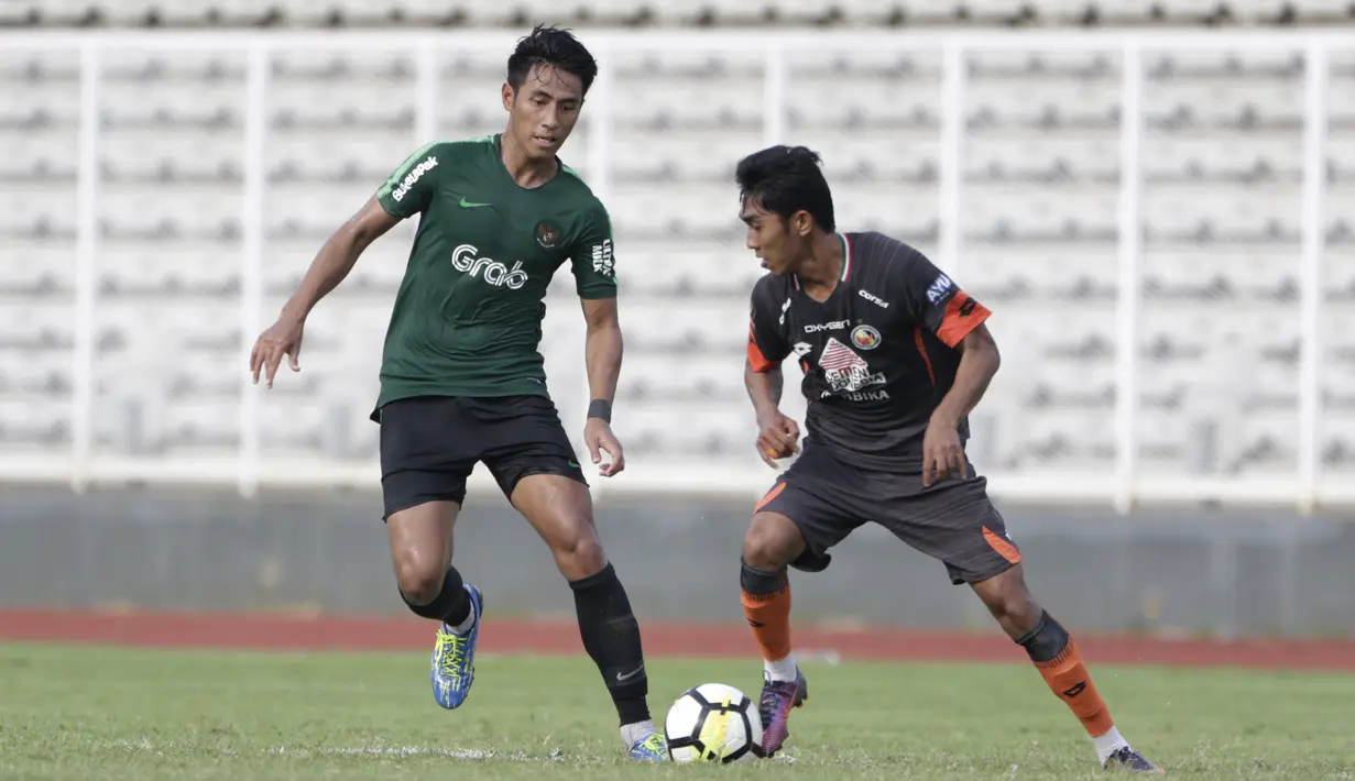 Gelandang Timnas Indonesia U-23, Hanif Sjahbandi, berusaha merebut bola saat melawan Semen Padang pada laga ujicoba di Stadion Madya, Jakarta, Selasa (12/3). Keduanya bermain imbang 2-2. (Bola.com/Vitalis Yogi Trisna)