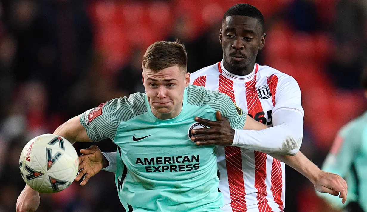 Pemain Brighton and Hove Albion Evan Ferguson (kiri) bersaing memperebutkan bola dengan pemain Stoke City Axel Tuanzebe (kanan) pada pertandingan sepak bola putaran kelima Piala FA di Stadion bet365, Stoke on Trent, Inggris, 28 Februari 2023. Brighton and Hove Albion mengalahkan Stoke City dengan skor 1-0. (Oli SCARFF/AFP)