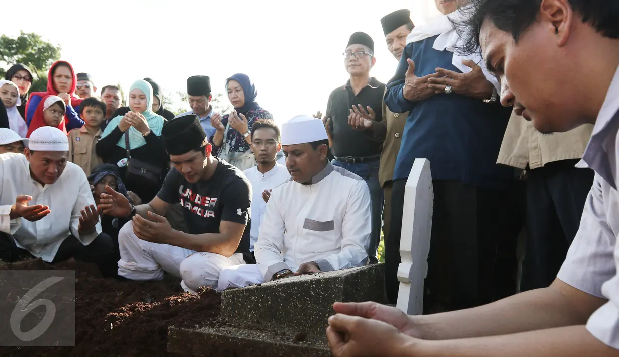 Aktor Iko Uwais berdoa di depan makam di depan makam ayahnya Musthafa Kamaluddin di TPU Prumpung, Jakarta, Rabu (8/3). Ayah Iko Uwais wafat pada  Rabu (8/3/2017) pagi di RSCM. (Liputan6.com/Herman Zakharia)