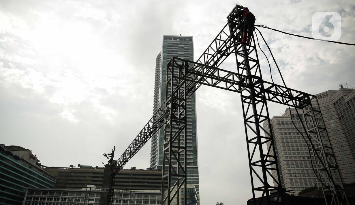 Pekerja menyelesaikan pembuatan panggung untuk acara malam tahun baru di sekitar kawasan Bundaran HI, Jakarta, Rabu (25/12/2019). Merayakan pergantian tahun, Pemprov DKI Jakarta menggelar sejumlah acara di sejumlah titik sepanjang Jalan Sudirman-MH Thamrin. (Liputan6.com/Faizal Fanani)