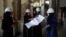 Para insinyur berhijab Afganistan mendiskusikan perbaikan istana Darul Aman, Kabul, 2 Oktober 2016. Istana ini dibangun di atas bukit kecil pinggiran Kabul pada awal 1920an setelah kemerdekaan Afghanistan penuh dari Inggris 1919. (REUTERS/Mohammad Ismail)