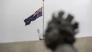 Bendera Australia berkibar setengah tiang di atas patung Ratu Elizabeth II Inggris di Gedung Parlemen di Canberra pada 9 September 2022. Ratu Elizabeth II meninggal usai kesehatannya menurun sejak beberapa tahun lalu dan membuat ia jarang tampil di hadapan publik. (Photo by AFP)
