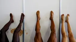 Peserta binaraga beristirahat dengan meregangkan kaki di belakang panggung saat kontes Arnold Klasik Eropa 2015 di Madrid, Spanyol, Jumat (25/9). (REUTERS/Susana Vera)