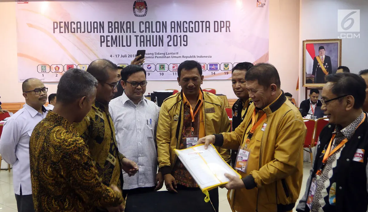Sekjen Partai Hanura Harry Lontung Siregar (dua kanan) menyerahkan berkas pendaftaran bakal calon legislatif kepada Komisioner KPU Hasyim Asy'ari (dua kiri) di KPU, Jakarta, Selasa (17/7). (Liputan6.com/JohanTallo)