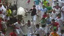 Para peserta berhamburan menyelamatkan diri dari serbuan banteng yang berlari liar di tengah kota saat Festival San Fermin Pamplona, Spanyol, Selasa (7/7/2015). (Reuters/ Vincent West)