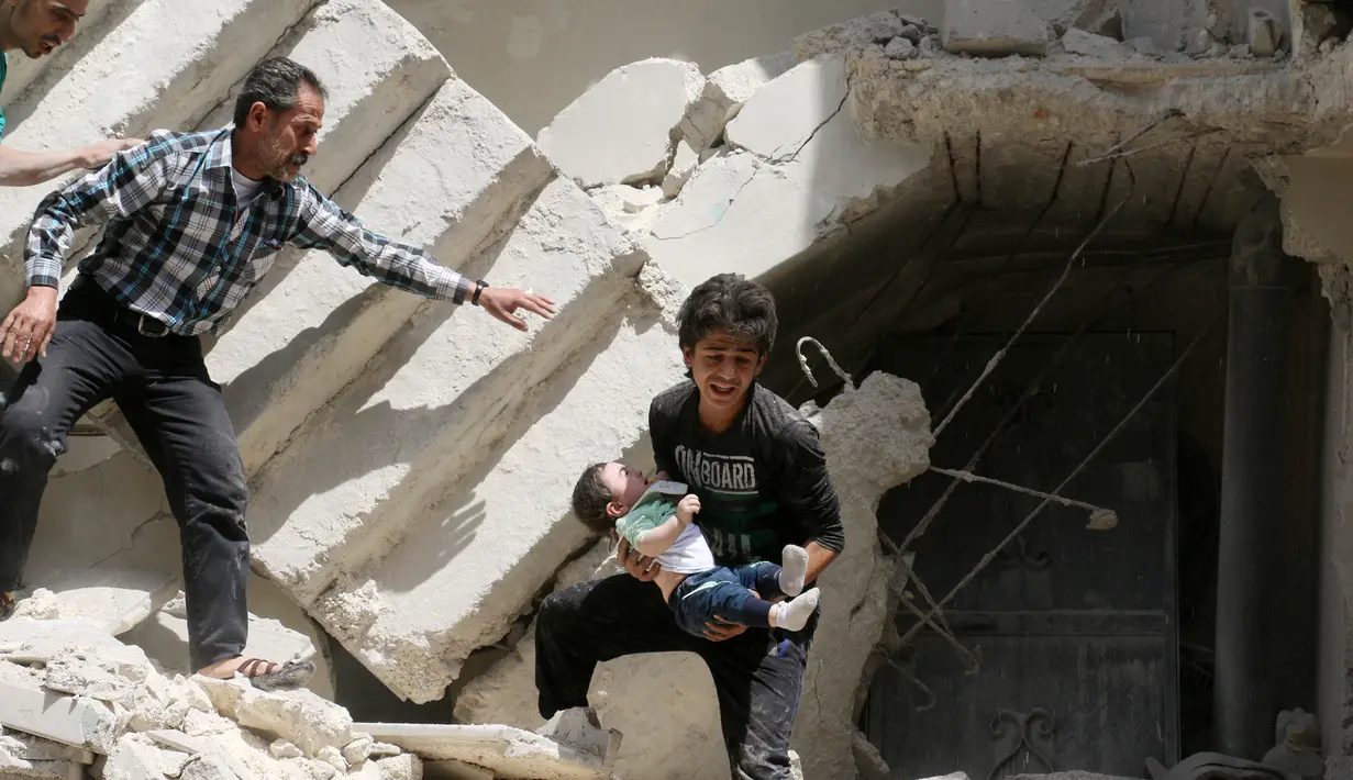 Relawan saat mengevakuasi bayi dari sebuah bangunan runtuh setelah serangan udara di wilayah yang dikuasai pemberontak al-Kalasa di kota Suriah bagian utara, Aleppo, Kamis (28/4). (AFP PHOTO / Ameer ALHALBI)