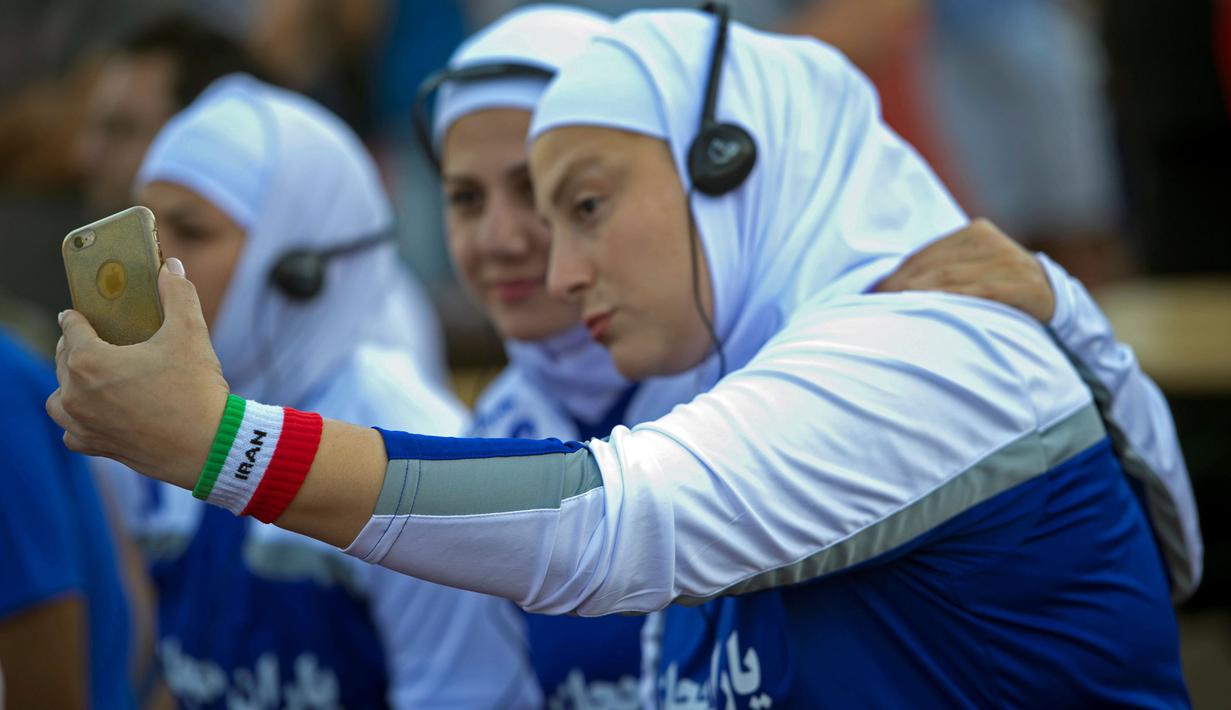 Gaya pemain bola putri dari Iran saat berfoto selfie sebelum berlaga melawan Jerman pada ajang  Discover Football tournamen di Berlin, Jerman, (31/8/2016). (REUTERS/Stefanie Loos)
