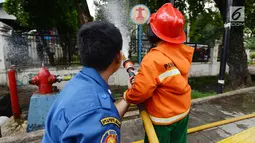 Petugas pemadam kebakaran mengajari anak TK cara memadamkan api di Jakarta, Kamis (21/3). Kegiatan ini bertujuan mengenalkan profesi pemadam kebakaran dan memberi pengetahuan proses pemadaman api kepada anak usia dini. (merdeka.com/Imam Buhori)