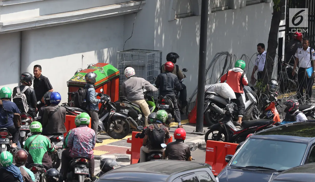 Sejumlah pengendara sepeda motor mencoba menerobos kawat berduri saat penutupan ruas Jalan Veteran akibat sidang sengketa Pilpres 2019 di Gedung MK, Jakarta, Selasa (18/6/2019). Penutupan Jalan Veteran mengakibatkan kemacetan lalu lintas di sekitar kawasan tersebut. (Liputan6.com/JohanTallo)