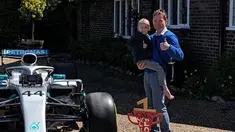 Bocah penderita kanker tulang langka Harry Shaw digendong ayahnya melihat mobil F1 yang dia terima dari Lewis Hamilton di Redhill, Surrey, Inggris, 13 Mei 2019. Hamilton menghadiahi mobil Mercedes yang dipakai dalam balapan F1 kepada bocah berusia lima tahun tersebut. (James Shaw/via REUTERS)